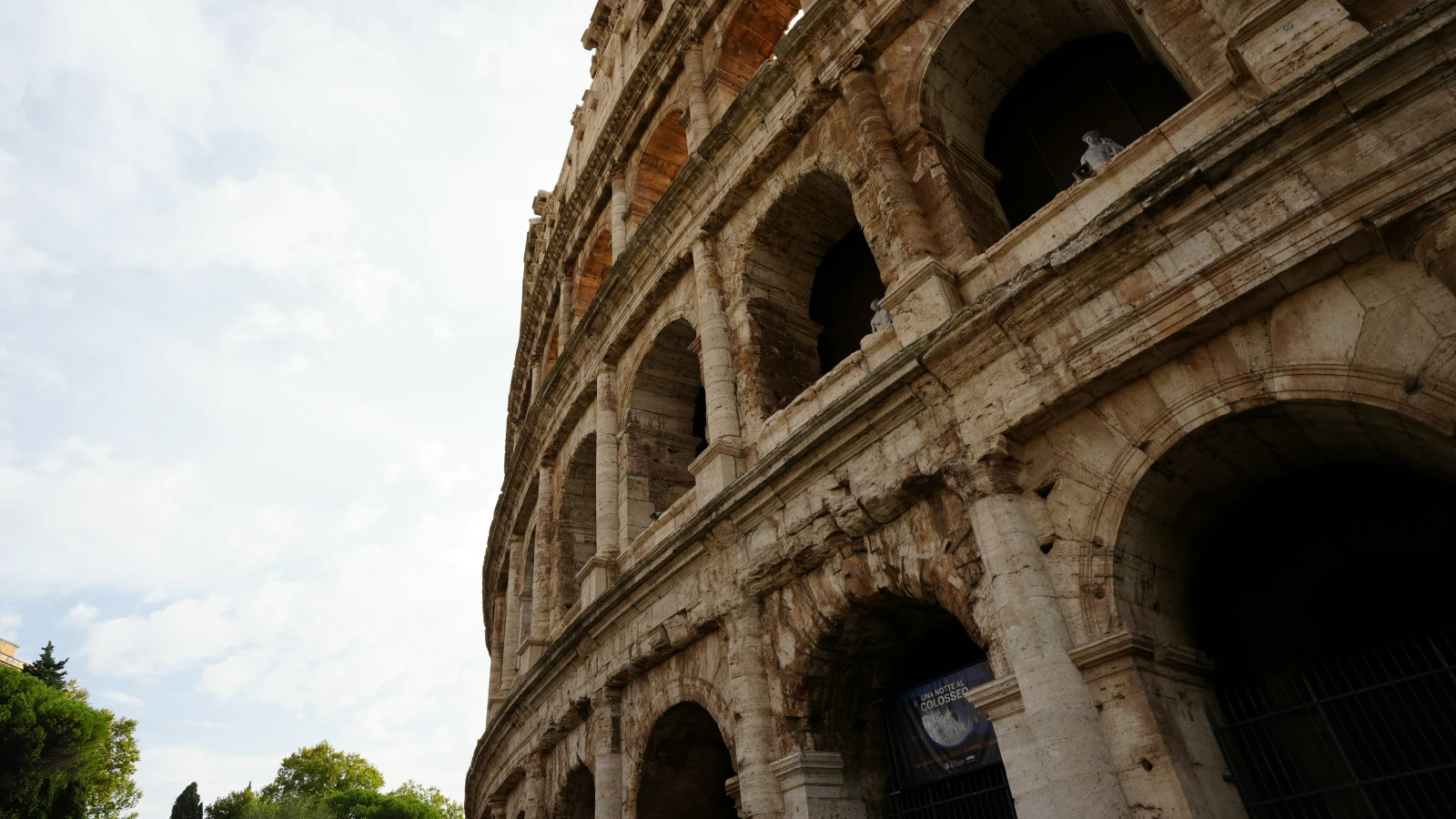 The Colosseum in Rome under a cloudy sky - car hire access and parking guide